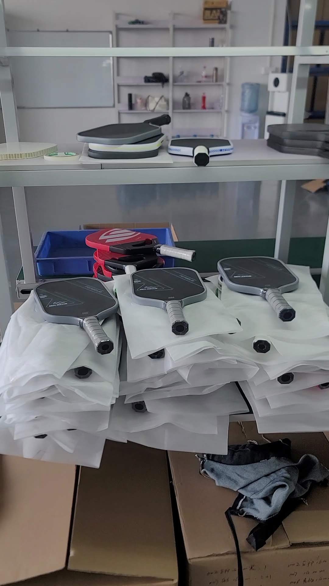 Finished pickleball paddles staged on factory shelf