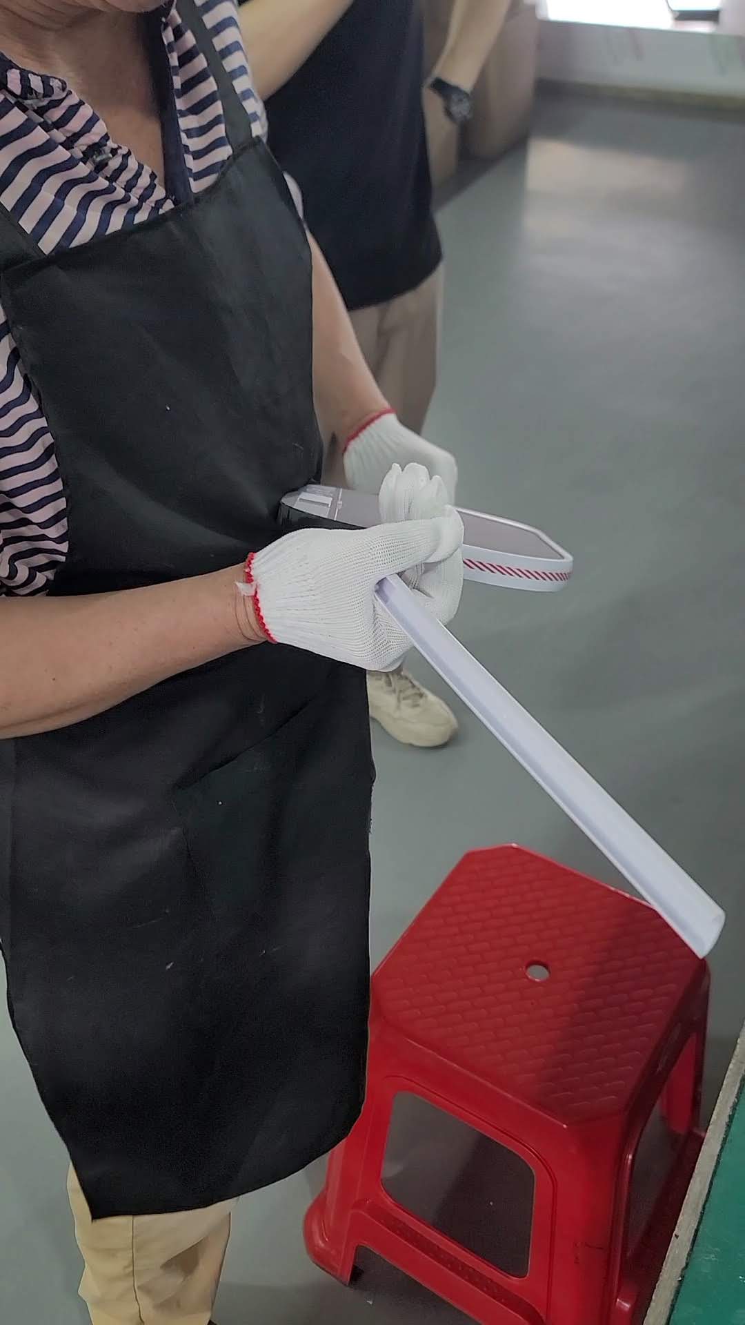 Worker finishing pickleball paddle handle by hand