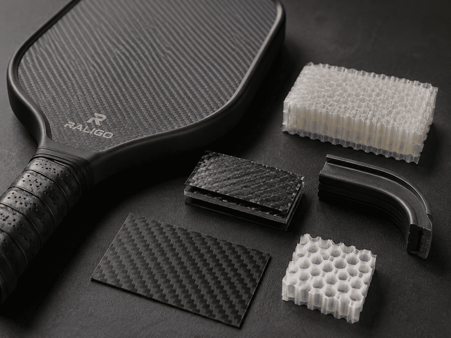 Carbon fiber paddle cutaway with rubber damping film, gel-core section, and urethane edge material samples